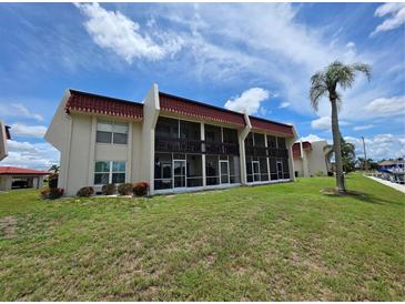 Exterior view of condo building with screened-in lanais and well-maintained lawn at 311 Garvin St # 405B, Punta Gorda, FL 33950