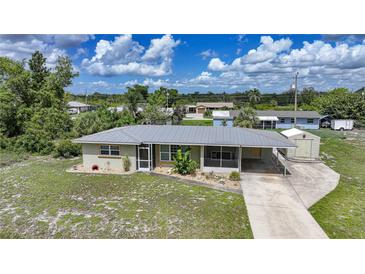 Charming single-story home with attached carport and ample yard space under a blue sky at 3171 Highlands Rd, Punta Gorda, FL 33983