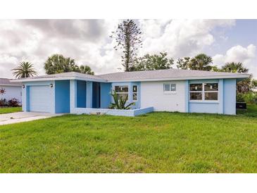 Charming single-story home showcasing a light blue and white exterior, green lawn, and attached garage at 37 Oakland Hills Ct, Rotonda West, FL 33947