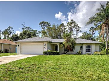 Well-maintained single-story home with a spacious lawn and attached two-car garage in a landscaped neighborhood at 4609 Jaslo Ave, North Port, FL 34286