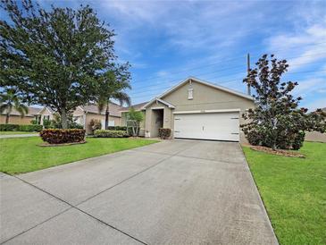 Well-maintained front yard featuring lush landscaping and a spacious driveway leading to a two-car garage at 7292 Mikasa Dr, Punta Gorda, FL 33950