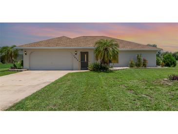 Charming one-story home with well-manicured lawn, attached garage, and inviting entryway at 1472 Oriel Ct, Punta Gorda, FL 33983