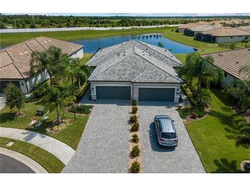 Beautiful home with a well-manicured lawn, paver driveway, tile roof and pond view at 15974 Clear Skies Pl, Bradenton, FL 34211