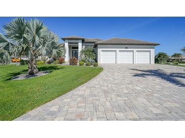 Beautiful home with a three car garage, landscaped yard and a paver driveway at 1801 Los Alamos Dr, Punta Gorda, FL 33950