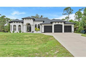 Stunning two-story home showcasing a manicured lawn and three-car garage at 3393 S Haberland Blvd, North Port, FL 34288