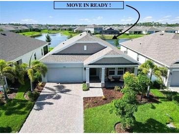 Charming single-story home featuring a two-car garage and covered front porch in a lakeside community at 16824 Canopy Garden Dr, Port Charlotte, FL 33953