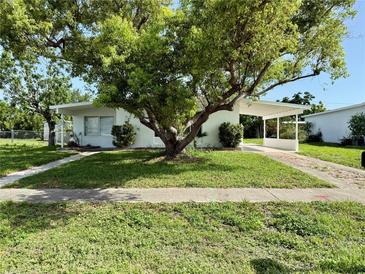 Charming single-story home featuring a carport and mature trees enhancing curb appeal at 21899 Cellini Ave, Port Charlotte, FL 33952