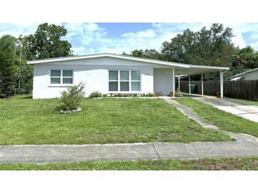 Charming single-story home with a well-maintained lawn, carport, and freshly painted exterior at 22334 Augusta Ave, Port Charlotte, FL 33952