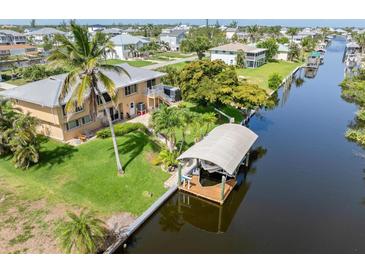 Waterfront home featuring a boat dock, lush tropical landscaping, and a tranquil canal view for serene living at 24398 Treasure Island Blvd, Punta Gorda, FL 33955