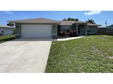 Charming single-story home with a well-manicured lawn and a two-car garage at 2443 Lake View Blvd, Port Charlotte, FL 33948