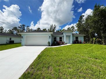 Charming single-story home with lush lawn, showcasing a clean, modern design with a two-car garage and light blue color palette at 2451 Waller Rd, North Port, FL 34288