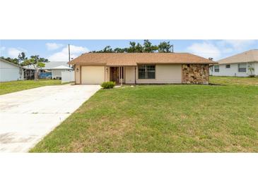 Charming single-story home with stone accents, a well-manicured lawn, and attached garage at 3242 Nocturne Rd, Venice, FL 34293