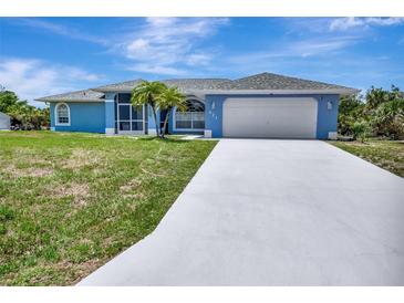 Charming single-story home with a two-car garage, well-maintained lawn, and freshly painted light blue exterior at 421 Strasburg Dr, Port Charlotte, FL 33954
