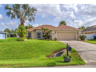 Inviting home featuring a lush lawn, palm trees and a charming exterior at 4268 Leesburg Ave, North Port, FL 34288