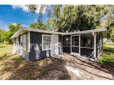 The exterior features grey painted siding, a white entry door and a screened patio at 4371 Guard St, Punta Gorda, FL 33980