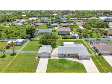 Expansive aerial view of a single-Gathering home with a spacious yard and a detached two-car garage at 4509 Wynkoop Cir, Port Charlotte, FL 33948