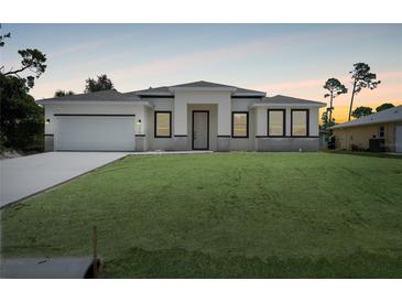 Charming single-story home featuring a well-manicured lawn, a two-car garage, and a welcoming entrance at 5018 Cillette Ave, North Port, FL 34288