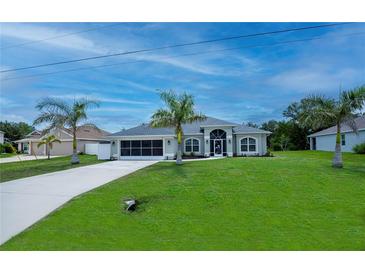 Charming single-story home featuring a well-manicured lawn and a long driveway lined with mature palm trees at 591 San Ambrosio St, Punta Gorda, FL 33983