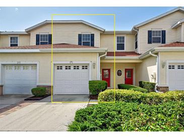 Charming townhome featuring a red front door, garage, and well-maintained landscaping at 1273 Jonah Dr, North Port, FL 34289