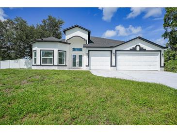 Charming single-Gathering home with a well-manicured lawn and three-car garage at 1523 Napoleon Rd, North Port, FL 34288