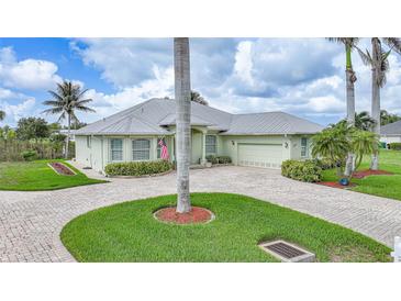 Well-maintained house with a circular driveway, lush lawn, and lovely landscaping at 15652 Havana Cir, Port Charlotte, FL 33981