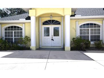 Inviting home entrance featuring a double door, arched window, and columns at 2244 Mauritania Rd, Punta Gorda, FL 33983