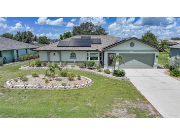 Charming one-story home with a well-manicured lawn, solar panels, and a cozy, welcoming entrance at 37 Pepe Ct, Punta Gorda, FL 33983