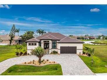 Stunning single-story home boasting a paver driveway, tile roof, and perfectly manicured landscaping at 609 Monaco Dr, Punta Gorda, FL 33950