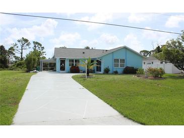 Charming single-story home with a well-maintained lawn, complemented by a long, patterned driveway at 6689 Gasparilla Pines Blvd, Englewood, FL 34224