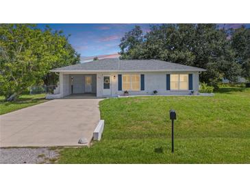 Charming single-story home featuring a well-maintained lawn and cozy curb appeal with an attached carport at 879 E Seminole Dr, Venice, FL 34293
