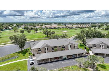 Beautiful aerial view of condos overlooking a golf course with covered parking and lush landscaping at 1375 Saxony Cir # 124, Punta Gorda, FL 33983