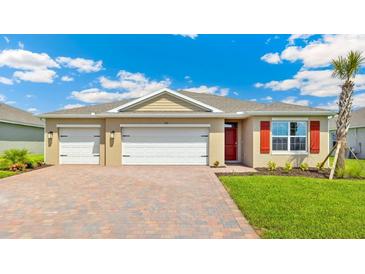 Charming single-story home with a three-car garage, paver driveway, and well-manicured lawn at 1472 Mableton Dr, Port Charlotte, FL 33953