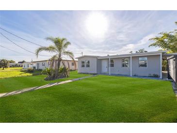Charming single-story home featuring a lush green lawn and mature palm tree in a sunny neighborhood at 175 Rodgers Ne Ave, Port Charlotte, FL 33952