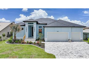 Charming blue single-Gathering home featuring a well-manicured lawn, beautiful flowerbeds, and a large two-car garage at 2815 Coral Way, Punta Gorda, FL 33950