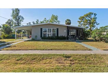 Charming single-story home featuring a covered carport, screened porch, and a well-maintained front lawn at 3197 Normandy Dr, Port Charlotte, FL 33952