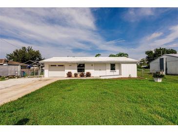 Charming single-story home featuring a well-manicured lawn and a bright white exterior at 3497 Cohoes St, Port Charlotte, FL 33952