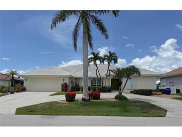 Charming single-story home with a well-manicured lawn, beautiful palms and a circular driveway at 1128 Rum Cay Ct, Punta Gorda, FL 33950