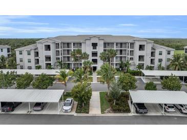 Exterior of a modern apartment complex with well-maintained landscaping and ample parking at 14081 Heritage Landing Blvd # 214, Punta Gorda, FL 33955