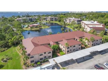 Stunning aerial view of a Roll's Landing condo community, showcasing lake, mature trees, and well-maintained buildings at 23465 Harborview Rd # 214, Punta Gorda, FL 33980