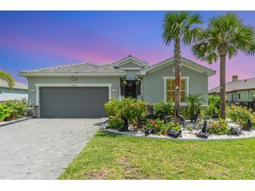 Beautiful one-story home featuring a well-maintained front yard with a two car garage and brick paver driveway at 24348 Nicobar Ln, Punta Gorda, FL 33955