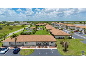 A stunning aerial view of a condo community showcasing well-manicured lawns and a sparkling pool at 25275 Rampart Blvd # 404, Punta Gorda, FL 33983