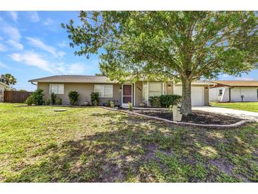 Charming one-story home with a well-manicured lawn, mature tree, and inviting curb appeal at 496 Fletcher St, Port Charlotte, FL 33954
