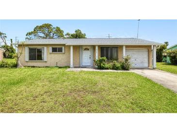 Charming single-story home with a well-manicured front yard and attached garage at 6540 Kenwood Dr, North Port, FL 34287