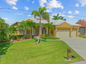 Beautiful home featuring a well-manicured lawn, palm trees, and a two-car garage at 1323 Mineo Dr, Punta Gorda, FL 33950
