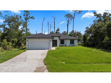 Charming single-story home featuring a two-car garage, well-maintained lawn, and inviting curb appeal at 17156 Eugene Ave, Port Charlotte, FL 33954