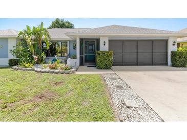 Charming single-story home featuring a well-manicured lawn, inviting entrance, and an attached two-car garage at 2141 Rio De Janeiro Ave, Punta Gorda, FL 33983