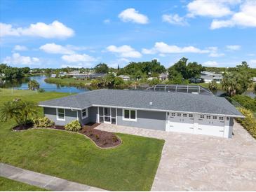 Beautiful single-story home featuring an attached three-car garage, landscaped yard, and waterfront views at 2309 Conway Blvd, Port Charlotte, FL 33952
