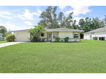 Charming single-story home with lush green lawn and mature landscaping, creating an inviting curb appeal at 4062 Blitzen Ter, North Port, FL 34287