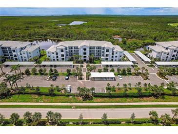 Gorgeous aerial view of condo complex with covered parking and lush tropical surroundings and water views at 14141 Heritage Landing Blvd # 921, Punta Gorda, FL 33955