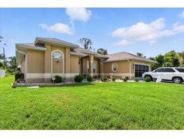 Beautiful single-story home featuring mature landscaping, an attached garage, and manicured lawn at 2329 Como St, Port Charlotte, FL 33948